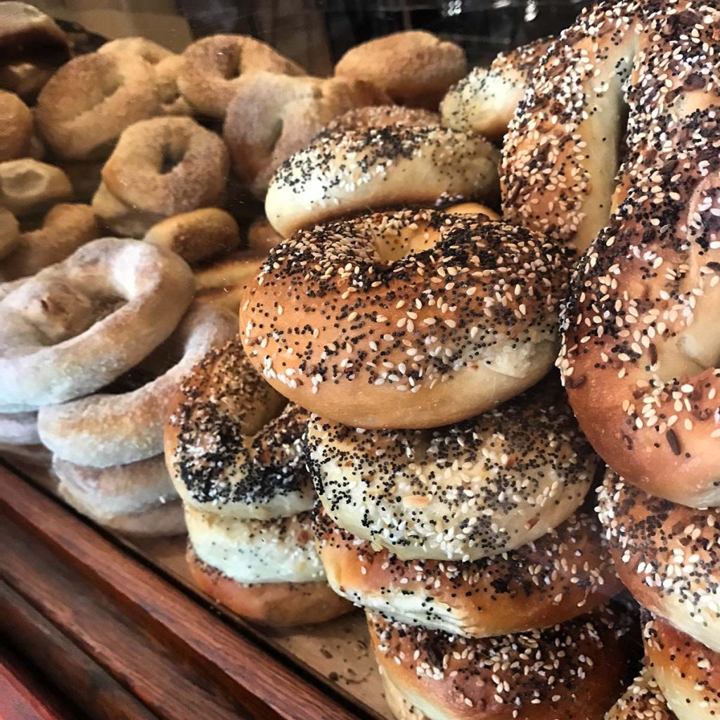 Stacked fresh bagels at Meshuggah Bagels